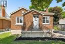 Brick-clad exterior with a prominent front entrance, featuring a concrete porch, black wrought iron railings, and a light gray front door - 714 Frederick Street, Kitchener, ON  - Outdoor 