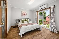 Bedroom featuring wood-finish flooring, light grey wall paint, and a textured white ceiling - 