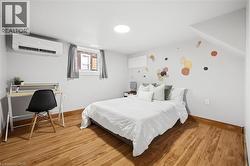 Wood-finish flooring with a white baseboard, light gray walls, and a white ceiling featuring a circular flush-mount light fixture - 