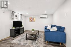 Finished interior space featuring wood-finish flooring, recessed lighting, and a wall-mounted mini-split HVAC system - 