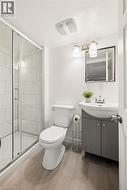 Shower enclosure with clear glass door, white rectangular wall tiles, and integrated shower head - 