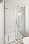 Enclosed shower featuring clear glass sliding doors and a chrome showerhead - 