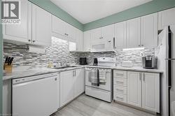 White shaker-style cabinetry with chrome hardware, marble-look countertops, and a mosaic tile backsplash - 