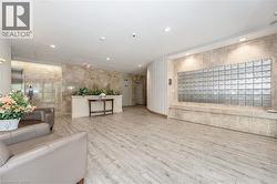 Building lobby featuring wood-finish flooring, recessed ceiling lighting, and extensive stone-finish wall coverings - 