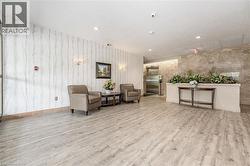 Lobby area featuring wood-finish flooring, a decorative accent wall, recessed lighting, and sconce fixtures - 