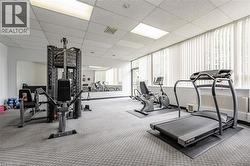 Dedicated fitness space featuring patterned carpet flooring and a suspended ceiling with integrated lighting - 