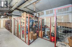 Dedicated storage units featuring metal mesh construction, concrete flooring, and overhead utility piping - 