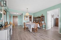 Open concept dining area featuring wood-finish flooring, a ceiling-mounted light fixture, and a neutral color palette - 