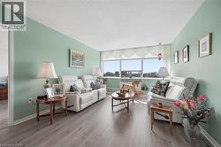 Spacious interior featuring wide plank wood-finish flooring and ample natural light from the expansive window - 