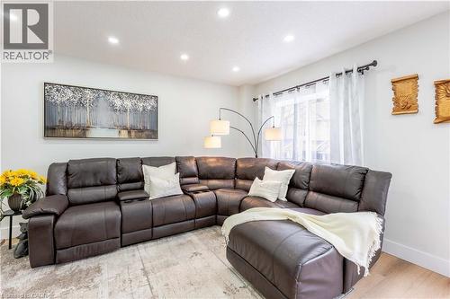 Recessed ceiling lighting illuminates this living space, featuring light-toned walls and wood-finish flooring - 185 Highland Crescent Unit# 2, Kitchener, ON - Indoor Photo Showing Living Room
