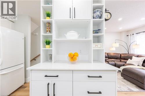White built-in cabinetry with open shelving and closed storage, featuring matte black hardware, a light-toned countertop, and wood-finish flooring - 185 Highland Crescent Unit# 2, Kitchener, ON - Indoor Photo Showing Other Room