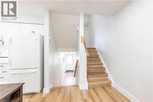 Light wood-finish flooring throughout, featuring a staircase with light wood treads and a complementary wood handrail - 185 Highland Crescent Unit# 2, Kitchener, ON - Indoor Photo Showing Other Room