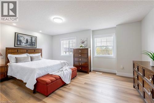 Room featuring wood-finish flooring, white baseboards, and two large windows with white trim - 185 Highland Crescent Unit# 2, Kitchener, ON - Indoor Photo Showing Bedroom
