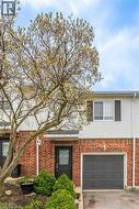 Brick and siding exterior featuring an attached garage with a panel door - 