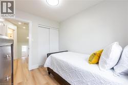 Compact room featuring light wood-finish flooring, white walls, and a ceiling-mounted flush light fixture - 