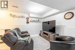 Recreation space featuring overhead lighting, light-toned walls with a chair rail, and soft-tone carpeting - 
