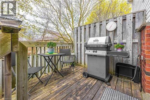 Private wood deck featuring a slatted privacy fence and brick exterior wall - 185 Highland Crescent Unit# 2, Kitchener, ON - Outdoor With Deck Patio Veranda