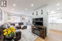 Open concept living area featuring recessed lighting, light wood-finish flooring, and a sliding glass door - 