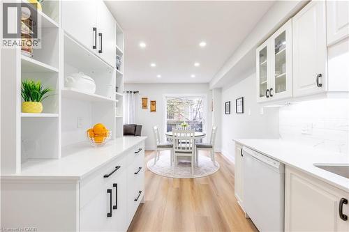 Modern kitchen featuring extensive white cabinetry with matte black hardware, white countertops, and a white subway tile backsplash - 185 Highland Crescent Unit# 2, Kitchener, ON - Indoor Photo Showing Kitchen