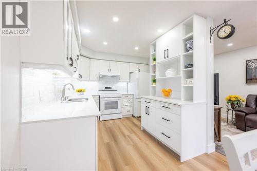 Kitchen featuring white shaker-style cabinetry, quartz countertops, and a white tile backsplash - 185 Highland Crescent Unit# 2, Kitchener, ON - Indoor Photo Showing Kitchen With Double Sink