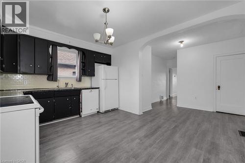 Kitchen featuring black cabinetry, a white subway tile backsplash, and dark countertops - 29 Harrison Avenue, Hamilton, ON - Indoor Photo Showing Kitchen