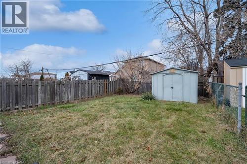 Expansive backyard featuring a metal storage shed, wood privacy fence, and chain-link fencing - 29 Harrison Avenue, Hamilton, ON - Outdoor