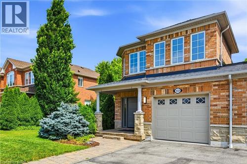 Brick exterior featuring stone accents, a covered front entry, and an attached single-car garage - 5628 Stella Lane, Burlington, ON - Outdoor