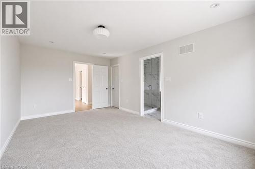 Spacious interior room featuring light-colored carpeting, white baseboards, and neutral wall paint - 5628 Stella Lane, Burlington, ON - Indoor Photo Showing Other Room