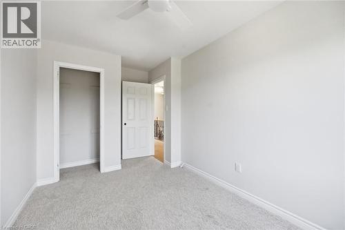 Neutral-toned room featuring light gray carpeting, white baseboards, and a ceiling fan - 5628 Stella Lane, Burlington, ON - Indoor Photo Showing Other Room