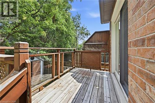 Outdoor wood deck featuring glass panel railings, a lattice privacy screen, and direct access to interior via a sliding glass door, all against a brick exterior - 5628 Stella Lane, Burlington, ON - Outdoor With Deck Patio Veranda With Exterior