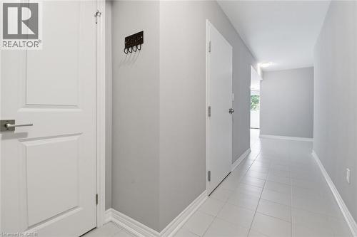 Hallway featuring light gray painted walls, white trim, square tile flooring, and white paneled doors with brushed nickel hardware - 5 Hagar Street, Thorold, ON - Indoor Photo Showing Other Room