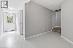 Entryway featuring light-toned tile flooring, a white glass-paned door, and painted trim - 