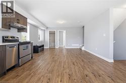 Open-concept living area featuring wood-finish flooring, light gray walls, and white trim - 