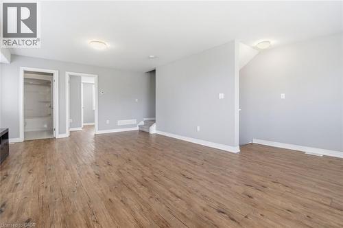Spacious room featuring wood-finish flooring, light gray wall paint, and white baseboards - 5 Hagar Street, Thorold, ON - Indoor Photo Showing Other Room