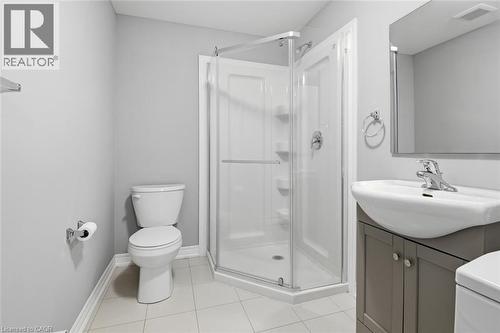 Bathroom featuring a corner glass-enclosed shower, white ceramic toilet, and a vanity with an integrated sink - 5 Hagar Street, Thorold, ON - Indoor Photo Showing Bathroom
