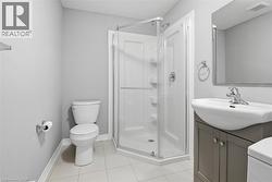Bathroom featuring a corner glass-enclosed shower, white ceramic toilet, and a vanity with an integrated sink - 