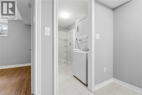 Laundry area with stacked appliances and tile flooring - 5 Hagar Street, Thorold, ON - Indoor