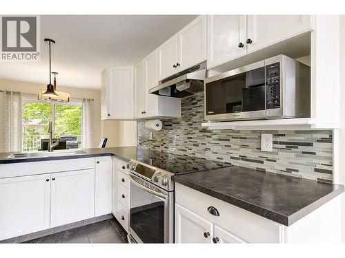 Functional kitchen with stainless steel appliances - 133 Wyndham Crescent Unit# 110, Kelowna, BC - Indoor Photo Showing Kitchen With Upgraded Kitchen
