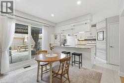 Kitchen featuring white cabinetry, light-toned countertops, tile flooring, and recessed lighting - 
