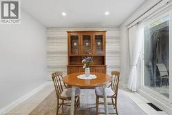Dining area featuring light-toned tile flooring, a horizontal striped accent wall, and recessed ceiling lighting - 