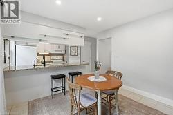 Modern kitchen featuring a breakfast bar with granite-style countertops and integrated sink - 