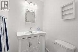 White vanity with integrated sink, chrome faucet, and storage cabinetry - 