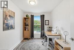 Bright room with a single window, overhead lighting, and wood-finish flooring - 