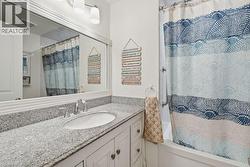 Bathroom with a white vanity featuring a built-in sink, chrome faucet, and a speckled countertop - 