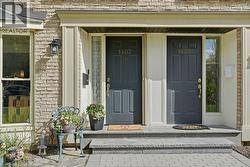 Brick exterior with two dark paneled entry doors, each featuring house numbers and decorative hardware - 