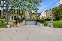 Underground garage with a white garage door, concrete driveway, and black metal railings - 