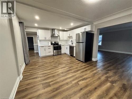 Modern kitchen featuring white shaker cabinetry, stainless steel appliances, wood-finish flooring, recessed lighting, and a matte black faucet - 773 Lawrence Road, Hamilton, ON - Indoor Photo Showing Kitchen