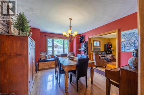 Dining area featuring wood-finish flooring, a built-in window seat with storage, and an ornate chandelier - 5 Hawthorne Avenue, Simcoe, ON - Indoor Photo Showing Dining Room