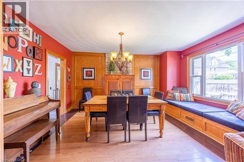 Dining area featuring wood-finish flooring, a built-in window seat with storage, and a built-in wood cabinet with stone accents - 5 Hawthorne Avenue, Simcoe, ON - Indoor Photo Showing Dining Room