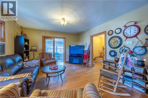 Living area featuring wood-finish flooring, a ceiling-mounted light fixture, and a doorway with wood trim - 5 Hawthorne Avenue, Simcoe, ON - Indoor Photo Showing Living Room